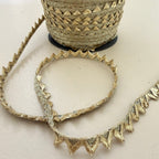 Gold zigzag chevron lace trim held in hand showing texture and width