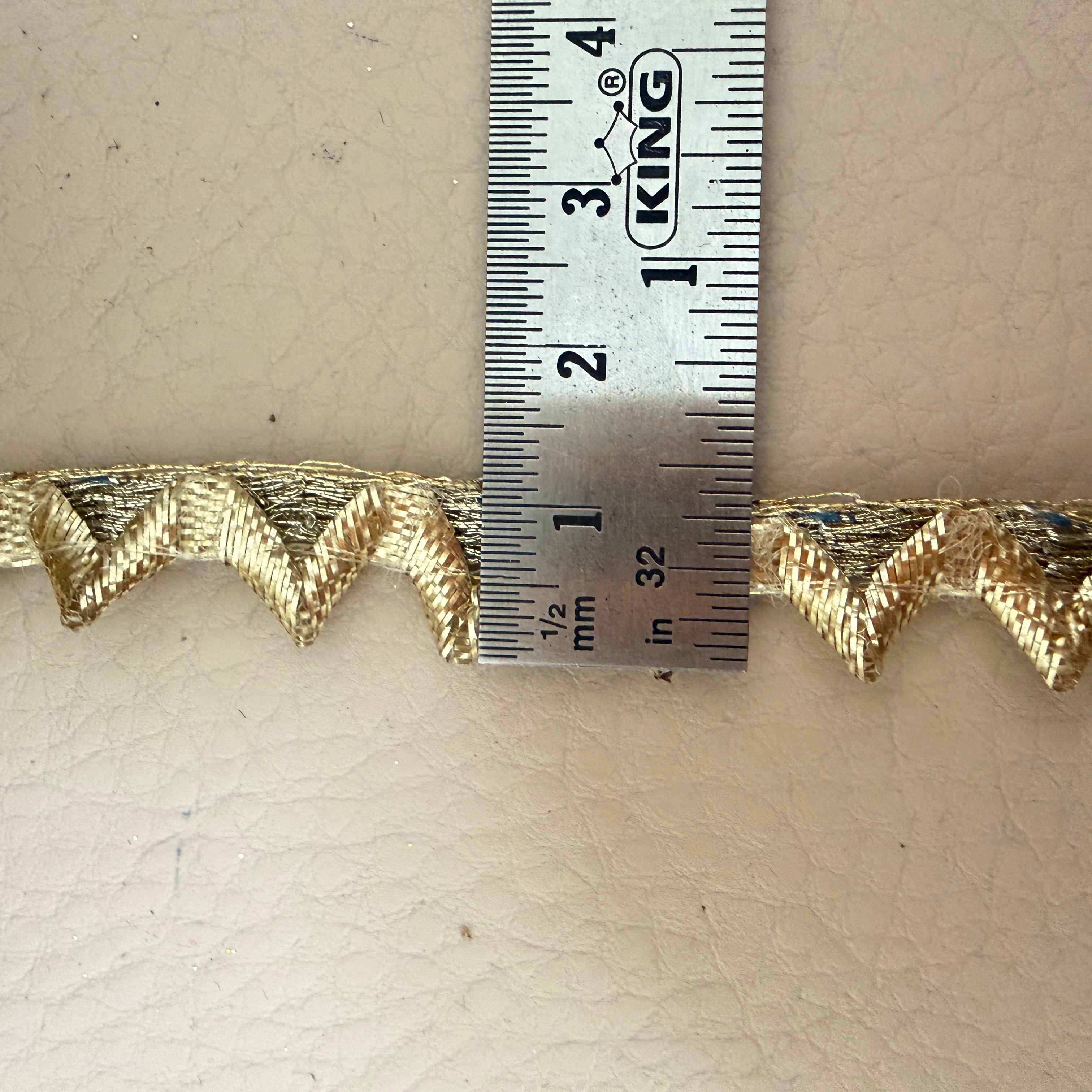 Full spool of gold zigzag chevron lace trim from top view