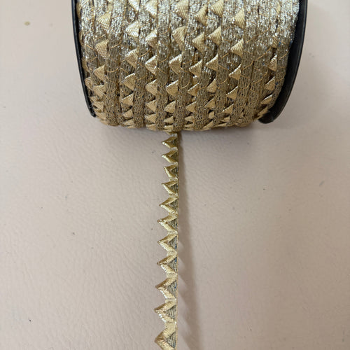 Gold zigzag lace trim measured with ruler showing approx 1cm width