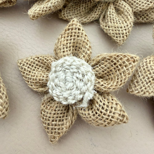 Multiple jute burlap flower patches held in hand showing size