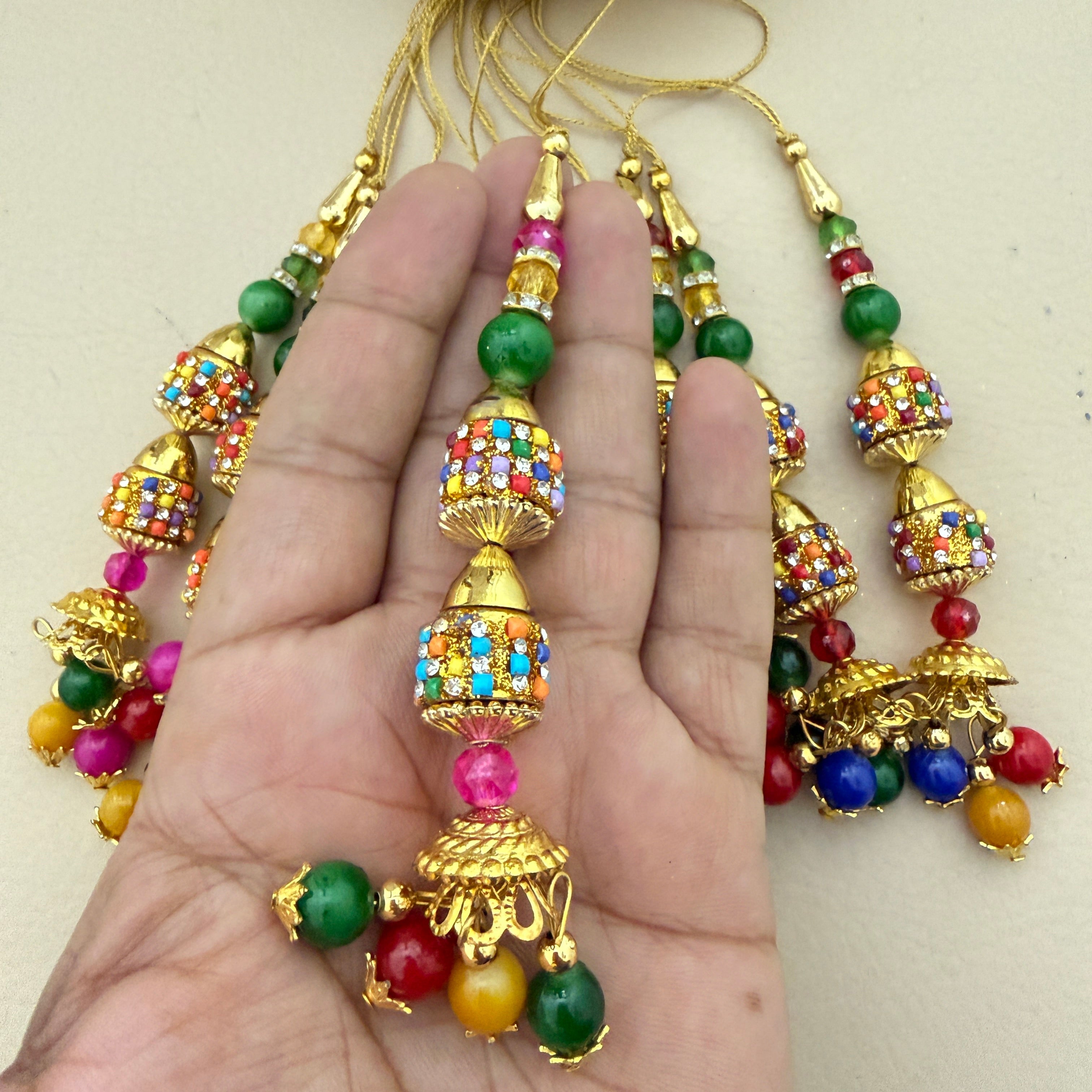 Multicolour jhumka latkans held in hand showing size and detail